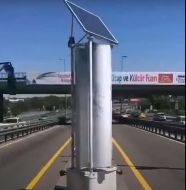 Wind Turbine and solar panel on a busy road
