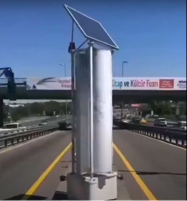 Wind Turbine and solar panel on a busy road